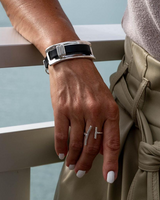 Hand wearing a bracelet and rings with a blurred background