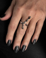 Adjustable irregular funky bar ring in silver-plated metal, worn on a hand with dark nails, displaying an edgy, artistic design.
