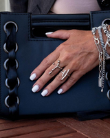 Adjustable irregular funky bar rings in silver finish worn on a hand with a black handbag, displaying a modern, edgy style.
