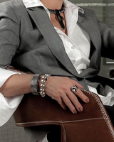 Person wearing a gray blazer and white shirt, sitting on a brown leather chair.