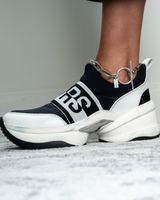 Bold chunky chain anklet with T-clasp, featuring a unique silver design showcased on an ankle next to a sporty black and white sneaker.