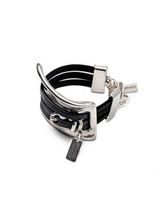Chunky black leather cuff bracelet featuring a large sculpted metal accent link and adjustable clasp. Unisex design.