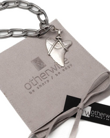 Silver chain bracelet with a pendant on a gray card featuring 'otherwise' branding.