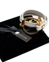 White and gold bracelet on a black box with 'Otherwise' brand tag