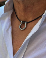 Necklace with a metal clasp worn by a person in a white shirt.