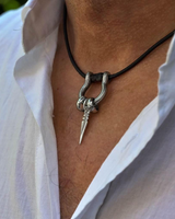 Silver pendant necklace on a person wearing a white shirt