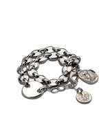 Silver chain bracelet with multiple charms on a white background