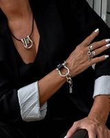 Equestrian-inspired necklace, bracelet, and ring set featuring oversized horseshoe shackles in silver and black leather.