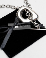 Chunky silver statement necklace and bracelet set featuring oversized organic links, laid on a black suede pouch.