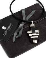 Statement black leather and metal bar choker necklace featuring sculpted metal accents and a supple leather cord, presented in a gift pouch.
