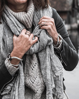 Person wearing a gray scarf with a blurred background