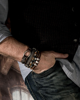Person wearing multiple bracelets on a blurred background