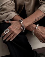 Zamak metal leather cuff bracelet with a modern stacked design, worn on a wrist, showcasing a spring opening closure.
