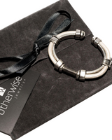 Zamak metal cuff bracelet with leather accents, featuring a modern stacked design and spring opening closure.