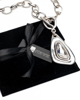 Swarovski crystal necklace with silver-plated metal, presented on a black suede pouch with a ribbon.