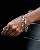 Hand wearing a silver bracelet with a black background
