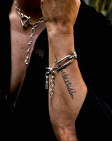 Person wearing a silver chain bracelet on a blurred background