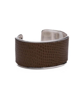 Brown leather cuff bracelet with silver rim on a white background