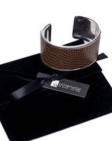 Brown textured bracelet on a black velvet pillow with 'otherwise' tag