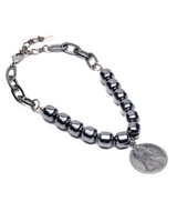 Edgy layered necklace set featuring dark polished gemstone beads and shiny stainless steel chain links, with a metal charm.