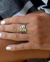 Silver-plated adjustable ring with irregular geometric design, worn on a hand with white nails, showcasing a modern edge.