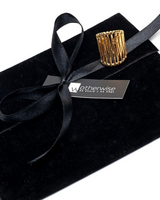 Black velvet box with a gold ring and black ribbon, branded 'otherwise'.