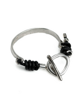 Silver bracelet with black beads on a white background