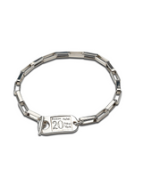 A silver-toned link bracelet with a rectangular clasp engraved with 'Room Hotel 20 New York', shown on a plain white background.