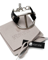Metallic peace sign keychain on a branded card with 'otherwise' branding.