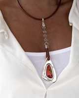 Necklace with a colorful pendant worn by a person in a white shirt