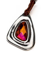 Pendant with a red gemstone and braided brown cord on a white background