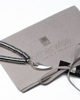 Necklace with a silver crescent moon pendant on a branded gray card with 'otherwise' logo.