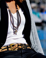 Person wearing a white top, gray cardigan, and leopard print belt with a blurred background