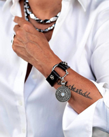 Brown leather horsebit cuff bracelet featuring a silver chain and a white opal Swarovski crystal pendant.