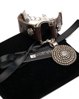 Brown leather horsebit cuff bracelet featuring a silver-tone horse bit buckle and a white opal Swarovski crystal pendant.