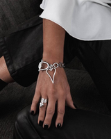 Chunky heart statement jewelry set featuring a choker necklace, bracelet, and adjustable ring, worn on a model's hand.
