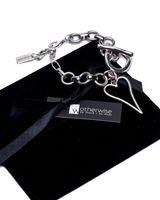 Chunky heart bracelet featuring a stainless steel chain and a heart pendant, presented on a black suede pouch.