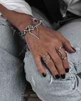 Chunky heart statement set featuring a silver choker with a large heart pendant, matching bracelet, and adjustable heart ring.