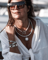 Three-piece silver lava leather jewelry set featuring layered necklaces and an adjustable bracelet, styled casually.