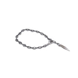 Silver ankle bracelet with oval links and a pointed dangle charm, showcasing a bold, edgy style.