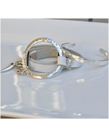 Silver bracelet and keychain on a white surface