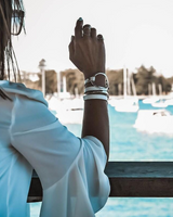 Person in a white dress looking at boats in a marina