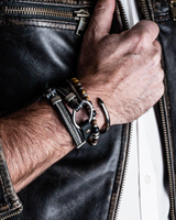 Hand wearing a keychain with keys on a leather jacket