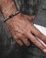 Hand wearing a beaded bracelet with a blurred background