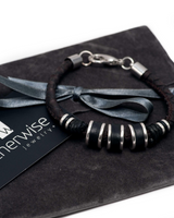 Silver-plated metal elements and dark brown PU leather create an edgy, flexible men’s bracelet with an adjustable fit.