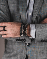 Person wearing a gray suit with arms crossed, focusing on the jacket and hands.