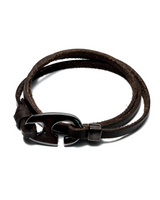 Brown leather bracelet with a dark metal clasp on a white background
