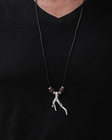 Person wearing a black shirt with a necklace featuring a unique pendant.