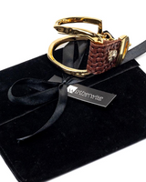 Gold and brown keychain on black velvet with 'Otherwise' brand tag