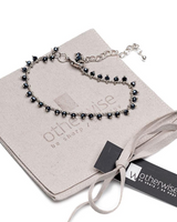 Black beaded bracelet on a branded jewelry pouch with 'otherwise' tag.